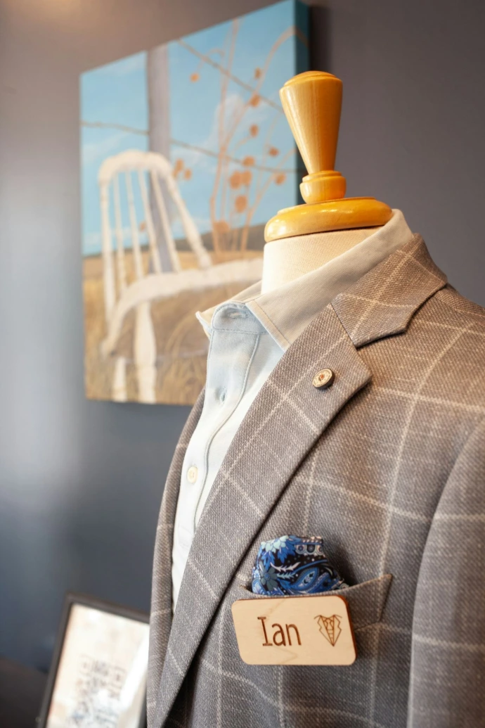 Mannequin wearing a grey plaid suit with name tag